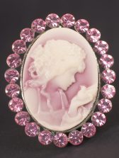 photograph of cameo, girl looking at hand surrounded by gemstones.