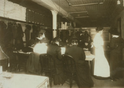 Women factory workers sitting at table.