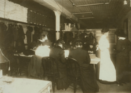 Women factory workers sitting at table.