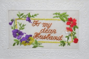Embroidered postcard reading For my dear husband, with flowers.