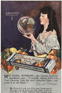 1919 California fruit gum ad, woman holding globe with fruit inside.
