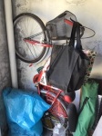 A bicycle standing on end in a garage.