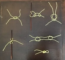 Six knots in yellow yarn on a table.