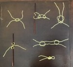 Six knots in yellow yarn on a table.