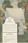 Nashua Wood Blankets ad, maid hanging blankets on line while children fold, Ladies' Home Journal, 1920.