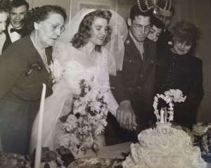 Rita Senger Stein with her son and daughter-in-law, cutting cake, at their wedding.